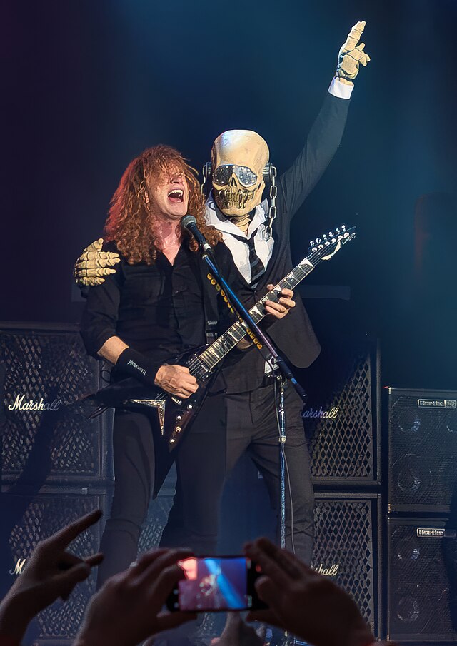 Dave Mustaine en concierto junto al personaje Vic Rattlehead de Megadeth sobre el escenario.